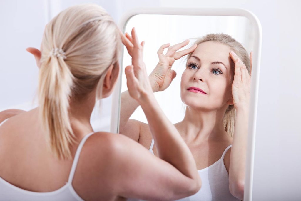 Woman admiring her wrinkle free forehead.  Sculptra Nubo Spa medspa Berkeley, CA.